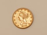 a close up of a gold coin on a white surface