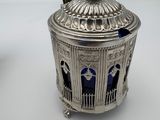 an image of a silver and blue container with a bird on top