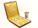 silverware in a wooden case with a cup and spoons
