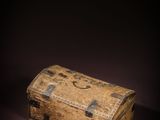 a small wooden box sitting on a dark surface