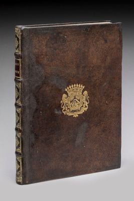 un vieux livre avec un emblème en or sur la couverture