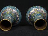 two blue vases are sitting side by side on a black surface