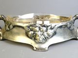 an antique silverplated bowl with a lion head on it