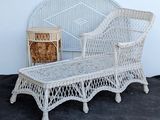 a white wicker bench and a wicker chair on the ground