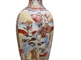 un vase orné d'une peinture posé sur une surface blanche