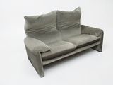 a grey couch with pillows on it on a white background