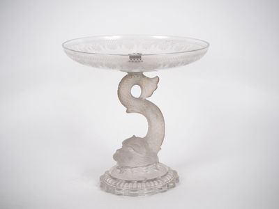 un socle en verre sur lequel est posé un oiseau, sur fond blanc