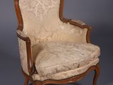 une vieille chaise avec une assise rembourrée beige et un cadre en bois