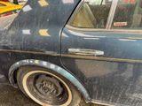 a dirty car parked on the side of the street