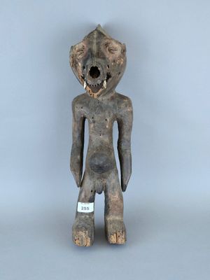 une image représentant une figurine en bois sur la poitrine de laquelle est accrochée une étiquette blanche