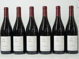 six bouteilles de vin sont alignées sur une table