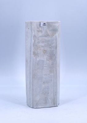 un vase en marbre blanc posé sur une surface blanche