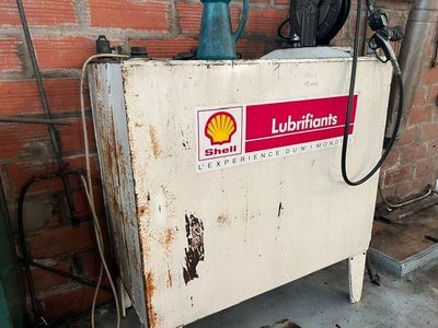 une machine blanche arborant un logo rouge en forme de coquille