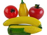 a banana, tomato, corn, and pepper on a plate