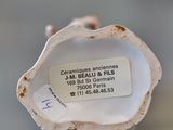 a small shell with a tag on it sitting on a table