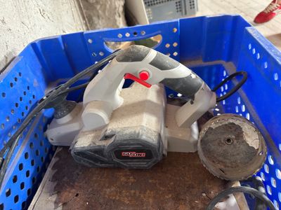 un panier bleu contenant une perceuse et un cordon d'alimentation