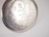 a close up of a silver plate with a design on it