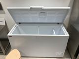 a white chest freezer sitting on top of a counter next to a chair