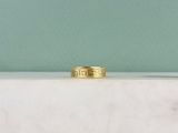 une bague en or posée sur un comptoir en marbre blanc