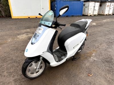 a white scooter parked in front of a building