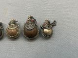 three small silver and gold christmas ornaments on a white cloth