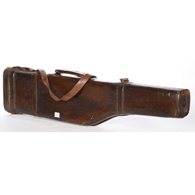 un vieil étui à guitare en cuir posé sur une surface blanche
