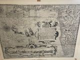 an old map is hanging on a wall next to a framed picture