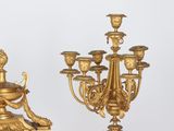 a gold colored clock and a gold colored candelabra