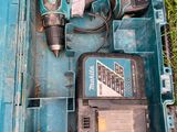 une boîte à outils bleue contenant des outils, posée sur l'herbe