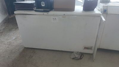 a small white refrigerator in the corner of a room