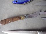 three knives and a knife sharper on a table