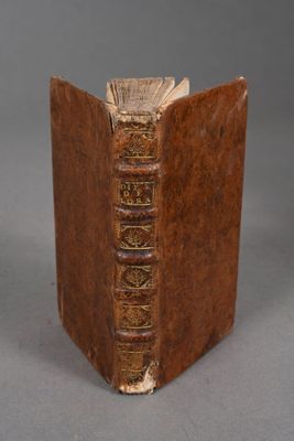 un vieux livre à la couverture brune posé sur une table