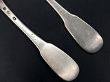 two spoons that are sitting next to each other