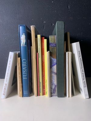 une pile de livres posée sur une table près d'un mur noir