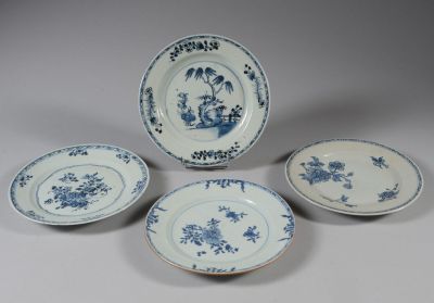 quatre assiettes bleues et blanches ornées de fleurs, posées sur une table