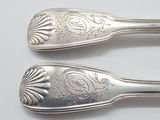two spoons that are sitting next to each other on a table