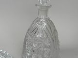 a glass bottle and a glass bowl on a table