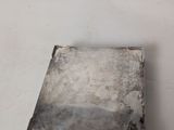 a silver tray that has a piece of metal on it