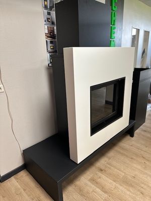 une cheminée noire et blanche dans une pièce avec du parquet