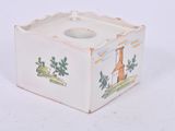 a small white candle holder with a picture of a church on it