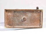 a metal box with a handle on a white surface
