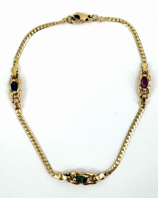 gros plan d'un bracelet en or avec des pierres multicolores