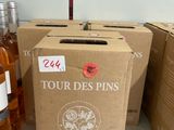 Plusieurs bouteilles de vin sont posées sur un comptoir, à côté d'un carton.