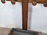 an image of a wooden coat rack with two coats on it