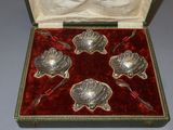 four silver spoons in a red velvet case