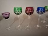 four wine glasses are lined up in a row on a table
