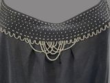 a close up of a black dress with silver beads on the neck