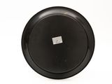 a black frisbee on a white surface with a sticker on it