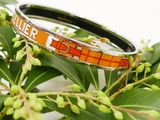 a close up of a bracelet on a tree branch
