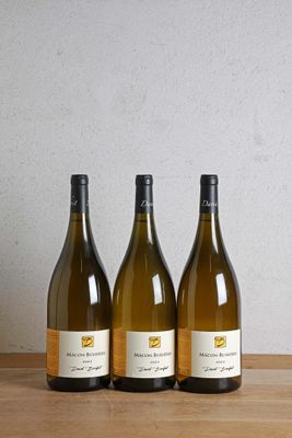 trois bouteilles de vin posées sur une table en bois, à côté d'une bouteille de vin
